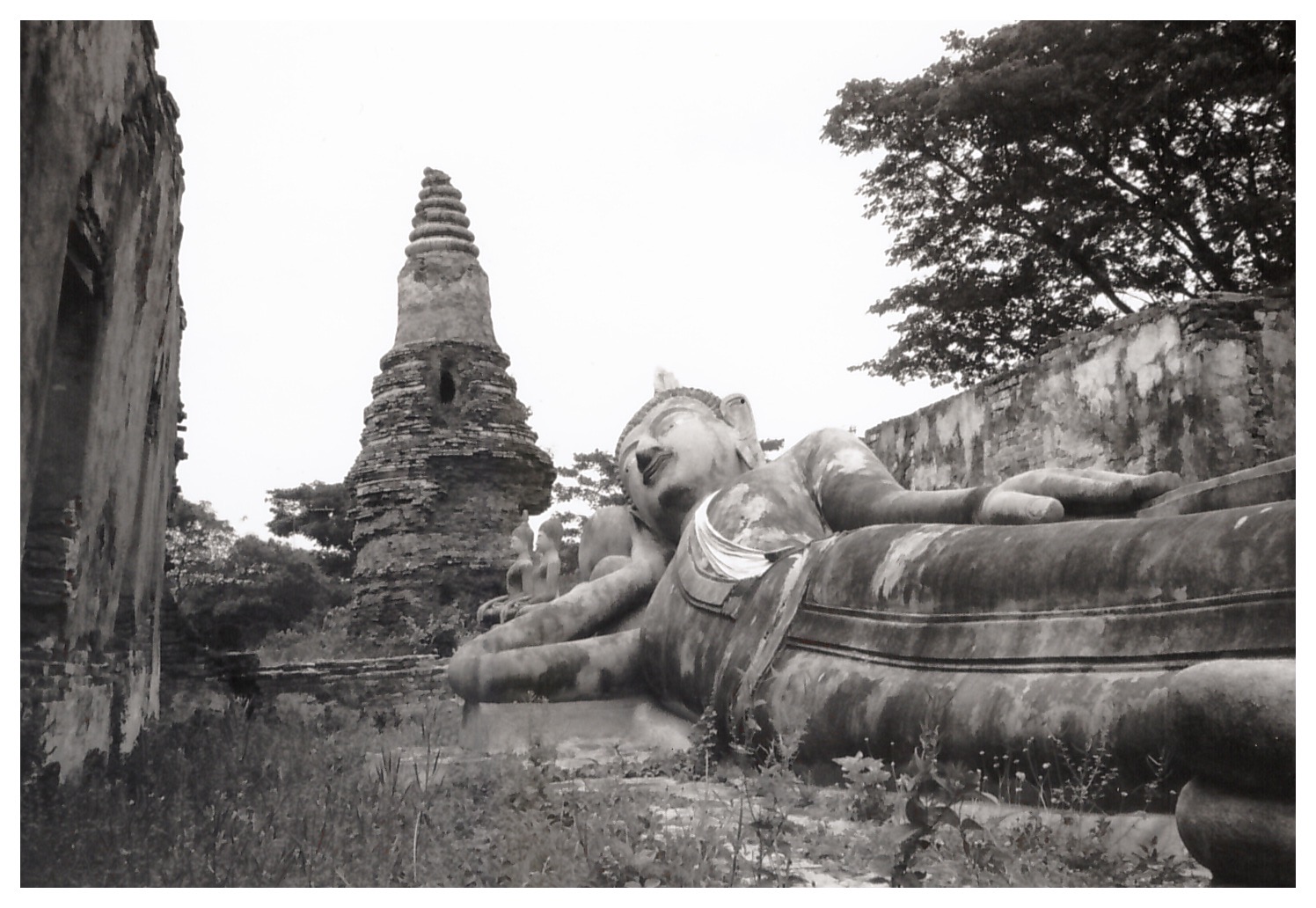 Large reclining Buddha statue surrounded by temple ruins