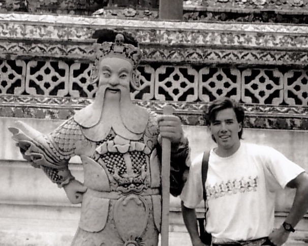 Brennon posing with a statue at Wat Arun, Thonburi, Thailand