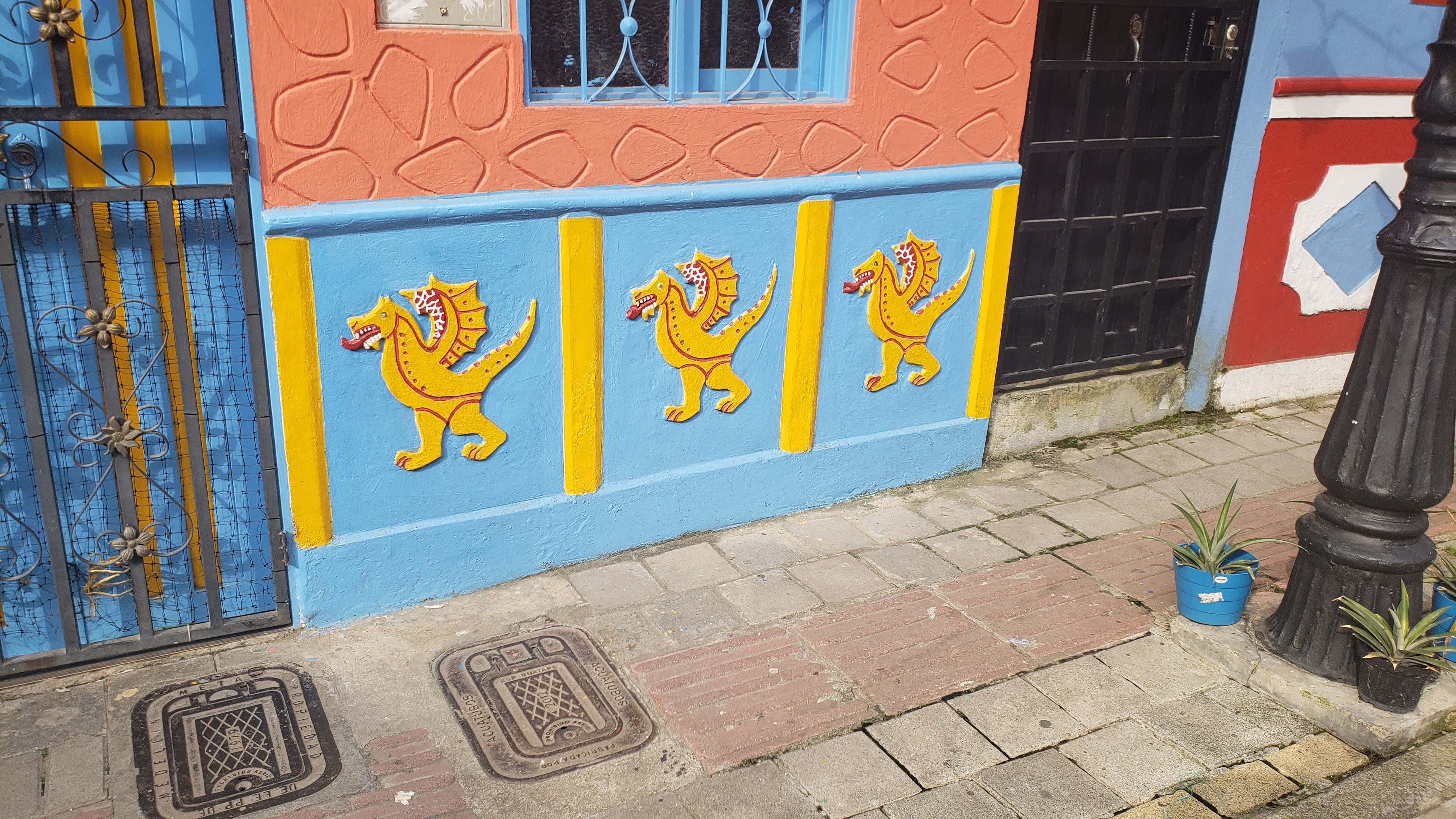 Three bas relief yellow dragons with red accents on a light blue background