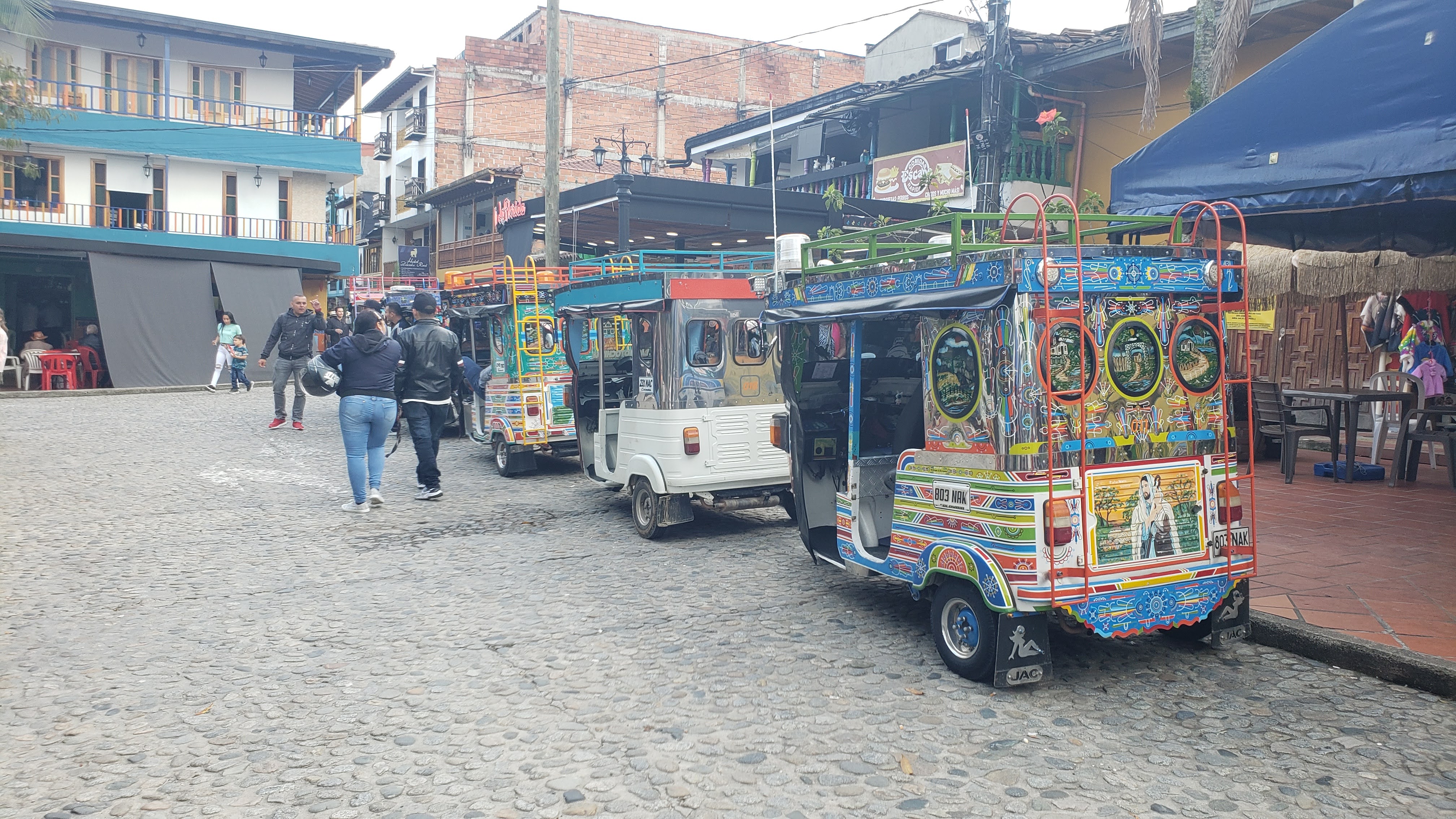 A row of colorful tuk tuks on the square in Guatapé