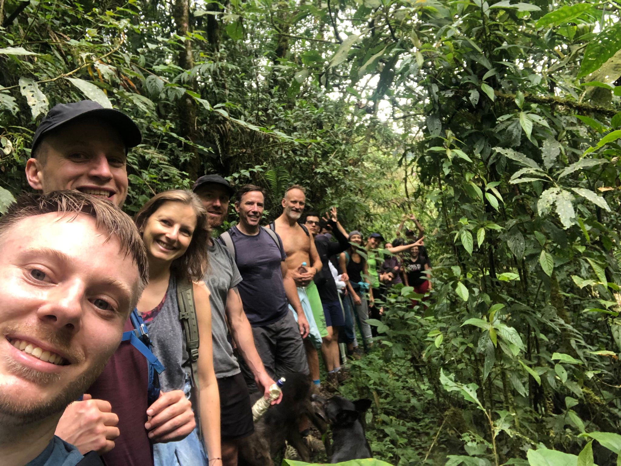 Group selfie of hikers stretched single file along a jungle trail