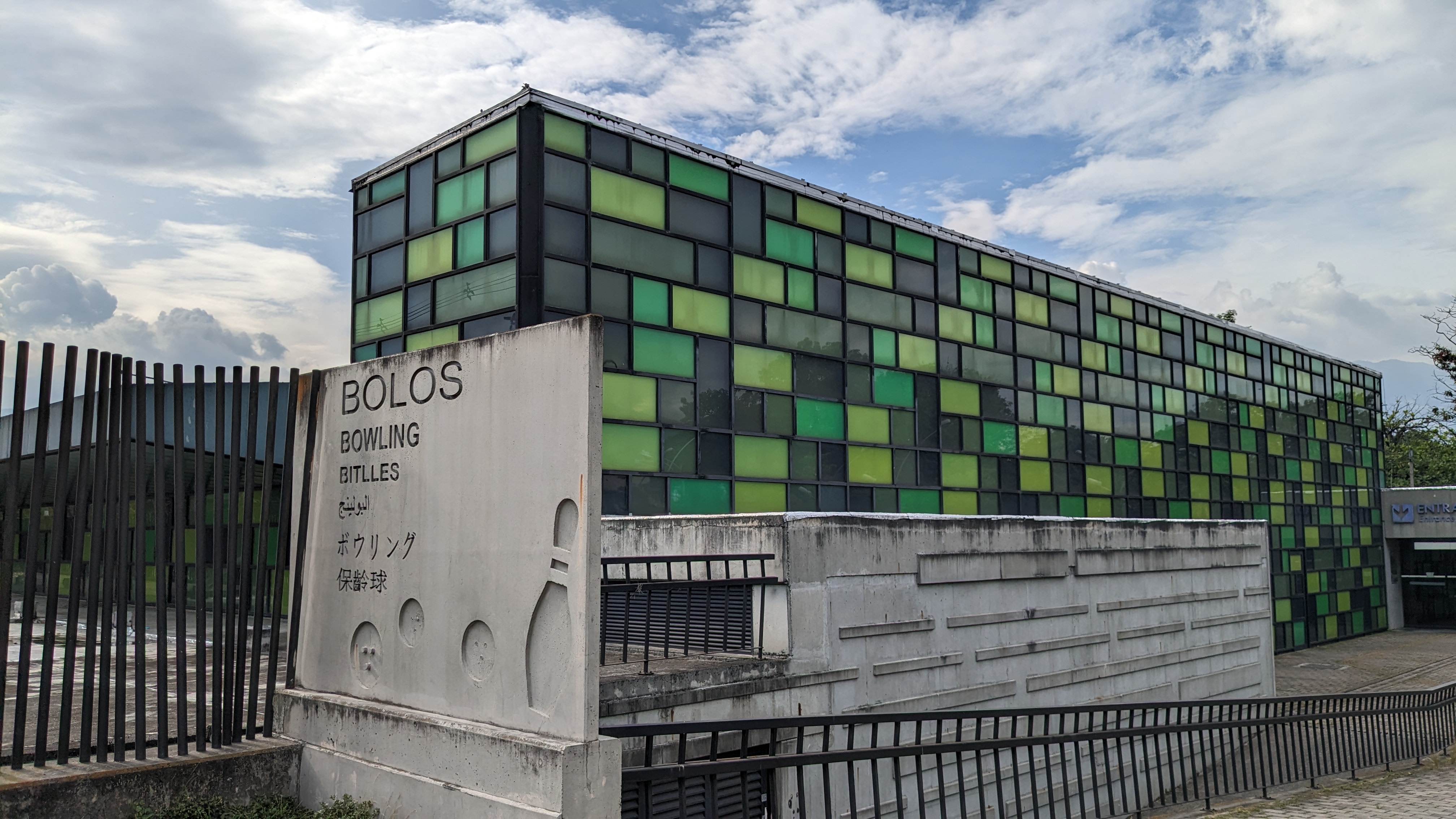 Modern, green glass building that contains a bowling alley