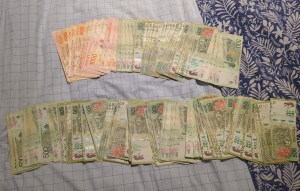 Argentinian peso notes fanned out on a bed