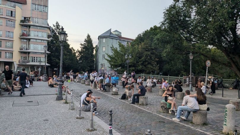 Berliners hanging out drinking beer on a bridge